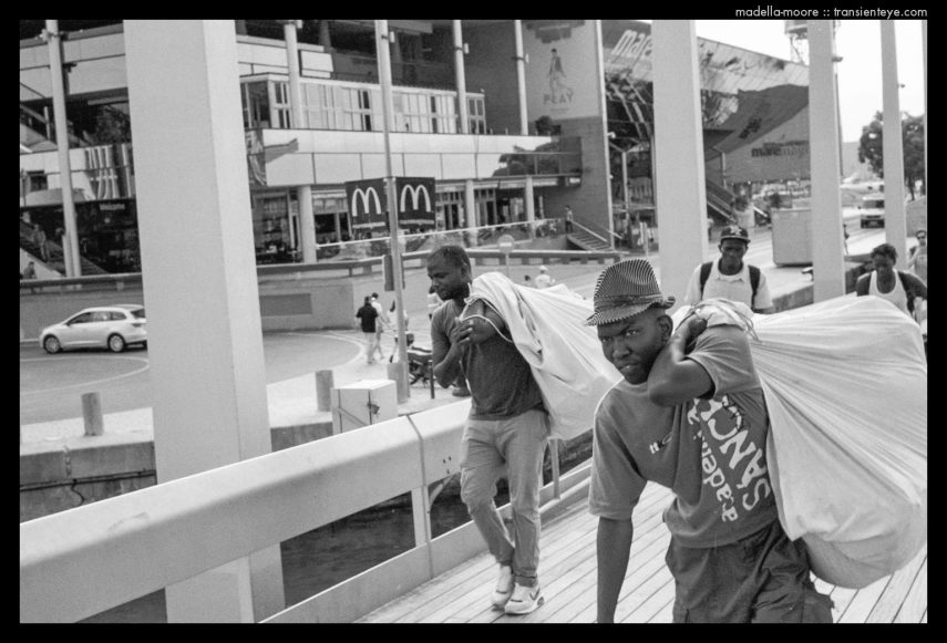 Escaping street sellers, Port Vell. Ilford HP5+. Leica M7. Zeiss ZM 1.5/50.